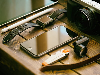 space iPhone 6 on top of brown table near black camera thumbnail