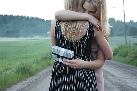 two women hugging in the middle of road thumbnail