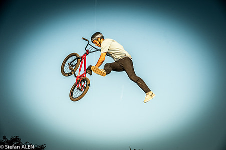 man doing trick with red BMX bike thumbnail