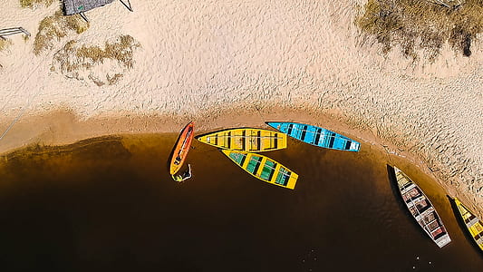 aerial photography of five assorted-color boats in shoreline thumbnail