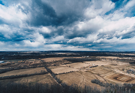 aerial view of field under cloudy sky thumbnail