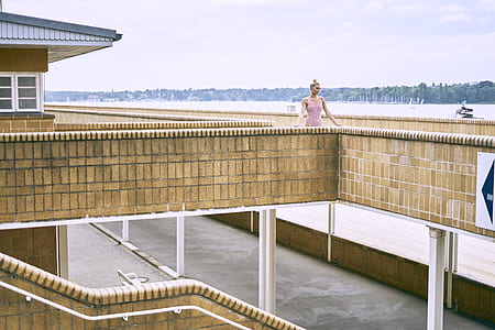 woman standing on terrace next to body of water thumbnail