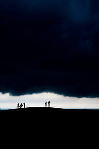 six people standing against white clouds thumbnail
