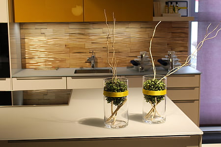 two brown twigs in clear glass vases on cupboard thumbnail