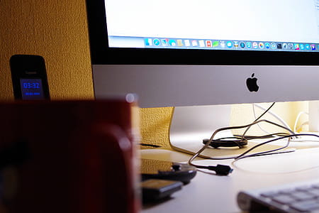 Silver Imac Turned on Beside Red Ceramic Cup thumbnail