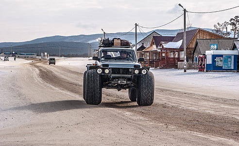 gray monster truck travelling on dirt road during daytime thumbnail