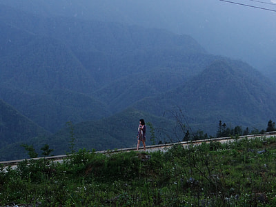 woman walking near mountain under blue sky thumbnail