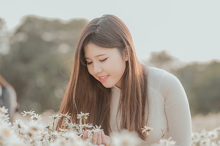 woman looking at flower thumbnail