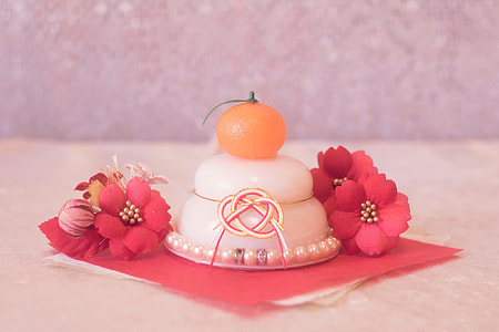 white and orange ornament with red petaled flower in a well lit room thumbnail