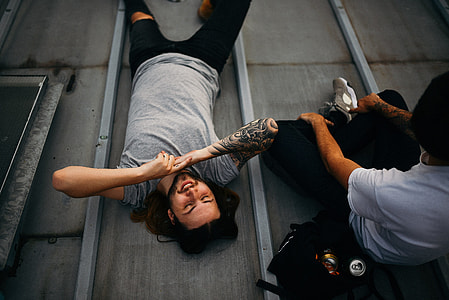 man in gray shirt lying beside person in white shirt thumbnail