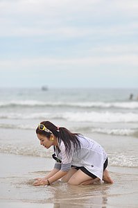 woman kneeling while playing on sand thumbnail
