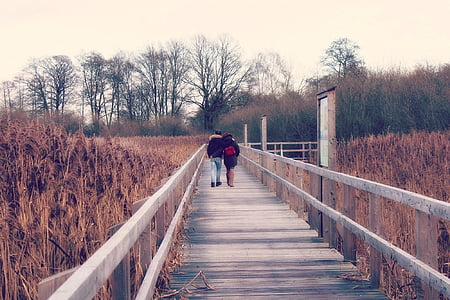 couple walking on the wooden dock thumbnail