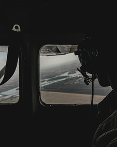 pilot wearing headphones looking outside window of aircraft thumbnail