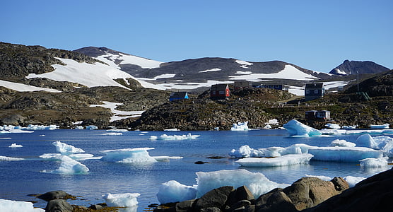 ice scattered on body of water near mountain thumbnail