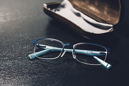 selective focus photo of eyeglasses beside clamshell case thumbnail