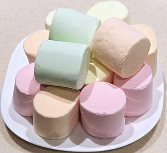 assorted-color marshmallows on white platter on beige surface thumbnail
