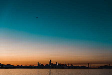 silhouette buildings and bridge under blue sky thumbnail