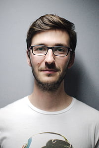 man in white shirt standing next to the wall thumbnail
