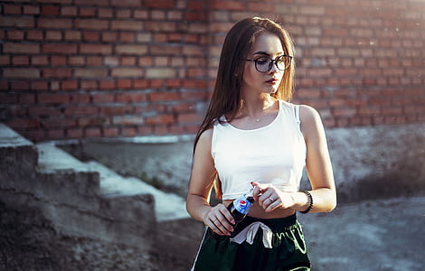 woman holding Pepsi bottle looking down in front brick wall thumbnail