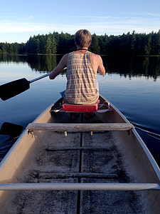 man rides on boat holding ore during daytime thumbnail