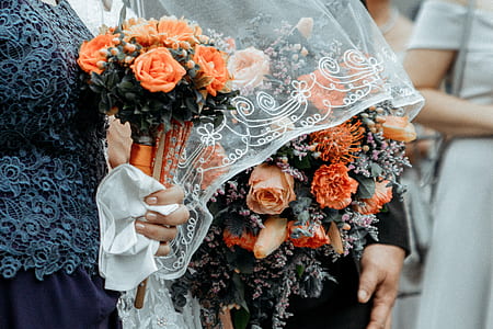 person holding bouquet of orange flowers thumbnail
