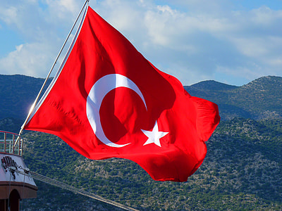 Turkey flag in front of green mountains during daytime thumbnail