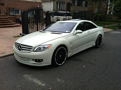 white Mercedes-Benz coupe parked near gate at daytime thumbnail