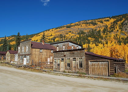 brown wooden house situated nearby mountain thumbnail