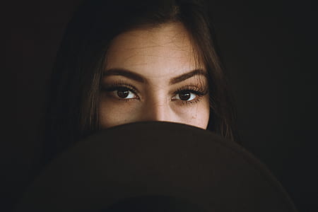 long black haired woman with black hat covers on her face thumbnail