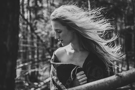 grayscale photography of woman standing beside tree thumbnail