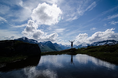 silhouette of person standing beside body of water thumbnail