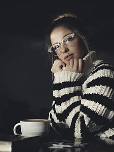 woman wearing white and black sweater with ceramic mug on table thumbnail