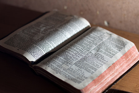 open bible on brown wooden surface thumbnail