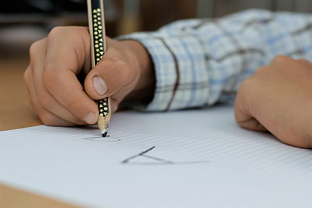 person writing on white paper using pencil thumbnail