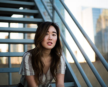 woman wearing red lipstick sitting on metal stairway at daytime thumbnail