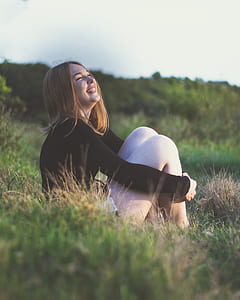 woman smiling white sitting on grass field thumbnail