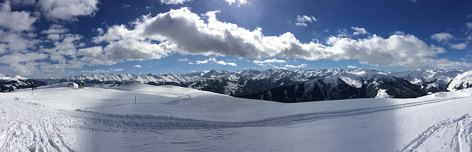 white snow field and black mountains under cloudy sky in panoramic photo thumbnail
