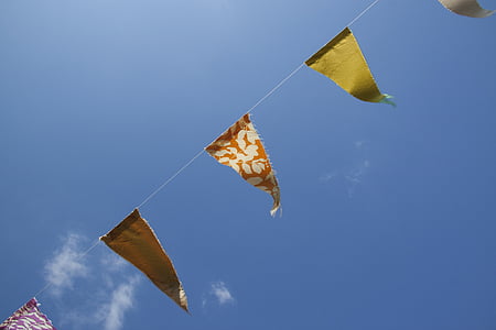 assorted-color bunting under clear blue sky during daytime thumbnail