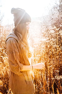 Woman in Black Beanie Standing Next to Tall Grass thumbnail