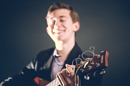 man playing brown Yamaha guitar thumbnail