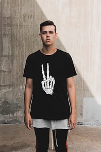 man wearing black and white peace skeleton hand print crew-neck t-shirt while standing thumbnail