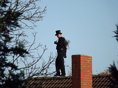 man walking on house roof near green leafed tree thumbnail