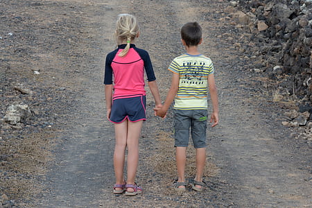girl and boy holding hands while standing thumbnail