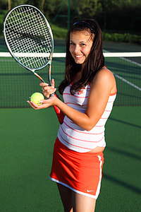 woman holding tennis racket and ball on field thumbnail