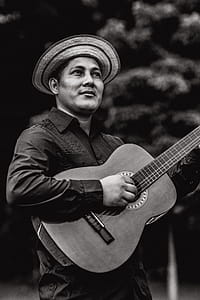 Grayscale Photography of Man Playing Guitar thumbnail