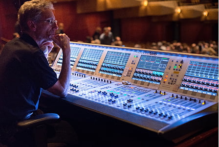 man behind DJ mixer that is turned on thumbnail