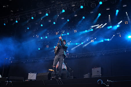man playing guitar performing on stage thumbnail