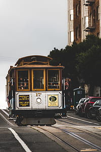 people riding on tram near building at daytime thumbnail