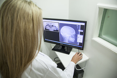 woman in white uniform holding computer mouse while looking on computer monitor thumbnail