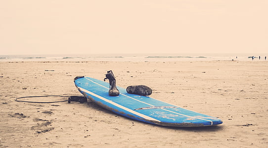 pair of boots on blue surfboard thumbnail